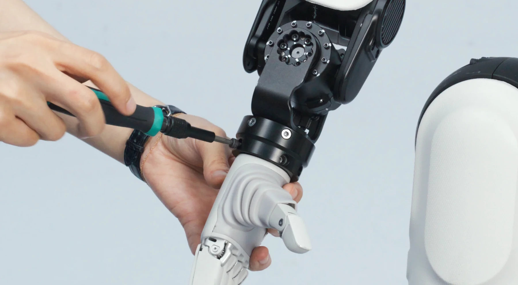 Technician installing the original Lite-S hand on a compact robot wrist